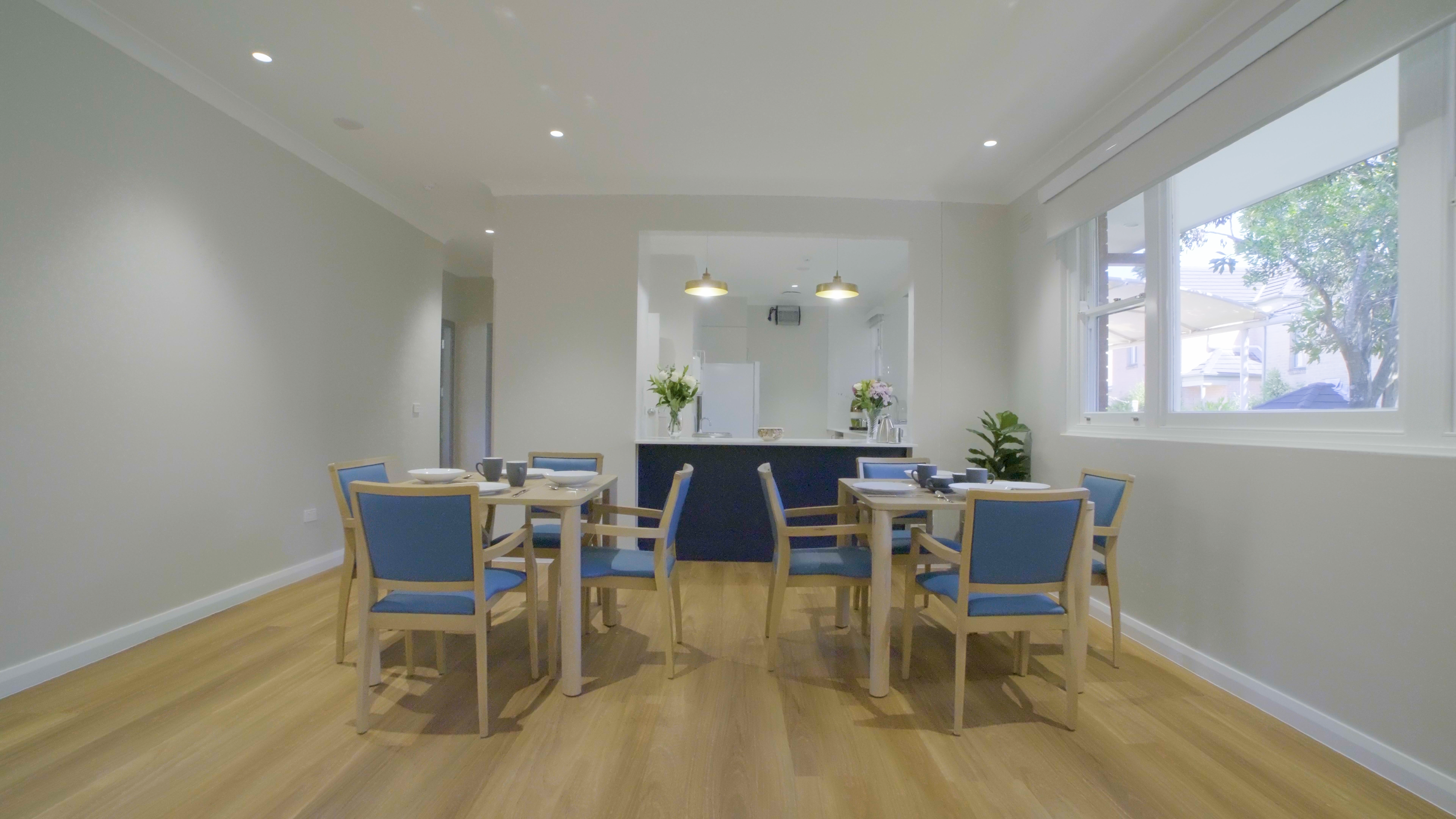 Chantal cottage room featuring a dining table, kitchen area, and stylish hanging lights. 