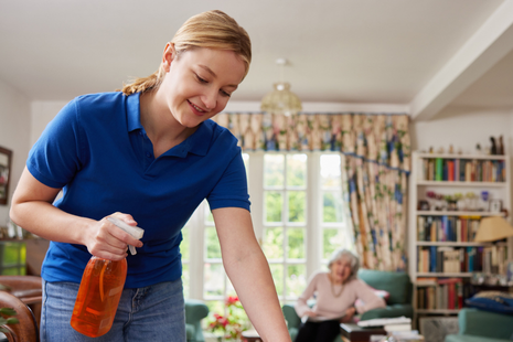 A healthcare professional, wearing scrubs and a stethoscope, holds an elderly woman&rsquo;s hands in a reassuring way, symbolising trust, empathy, and personalised medical care.